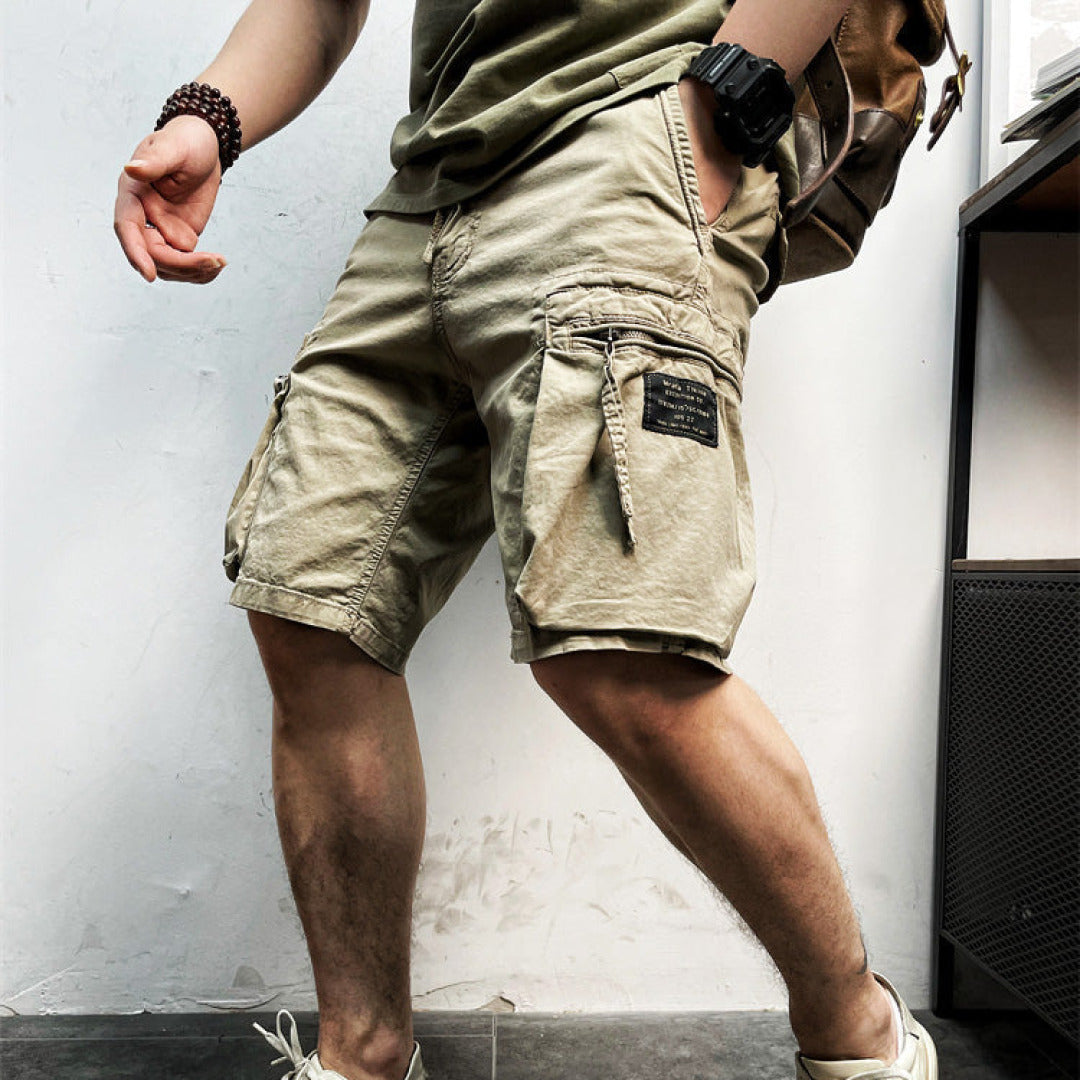 Man wearing khaki relaxed fit cargo shorts outdoors with backpack