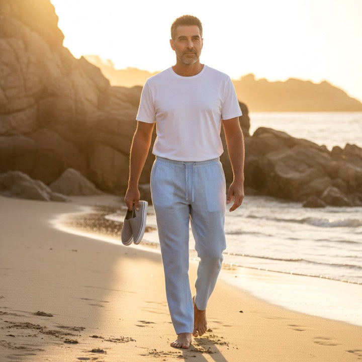 Man walking on a beach at sunset wearing lightweight summer trousers