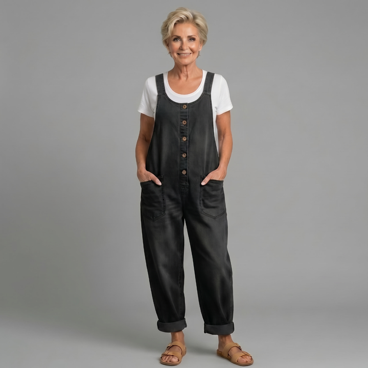 Model wearing black relaxed fit denim bib overalls
