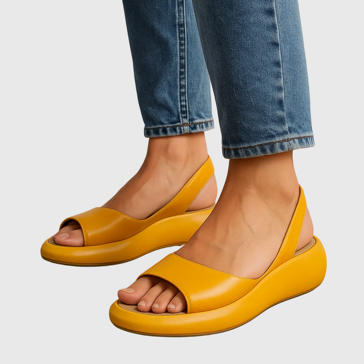 Woman wearing sunny yellow Briony slide sandals paired with blue jeans