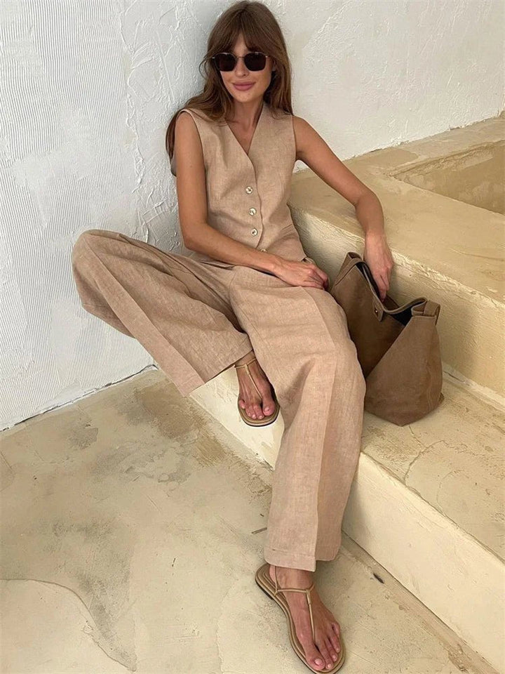 Woman sitting in the beige linen vest and pleated wide-leg pants set with sunglasses