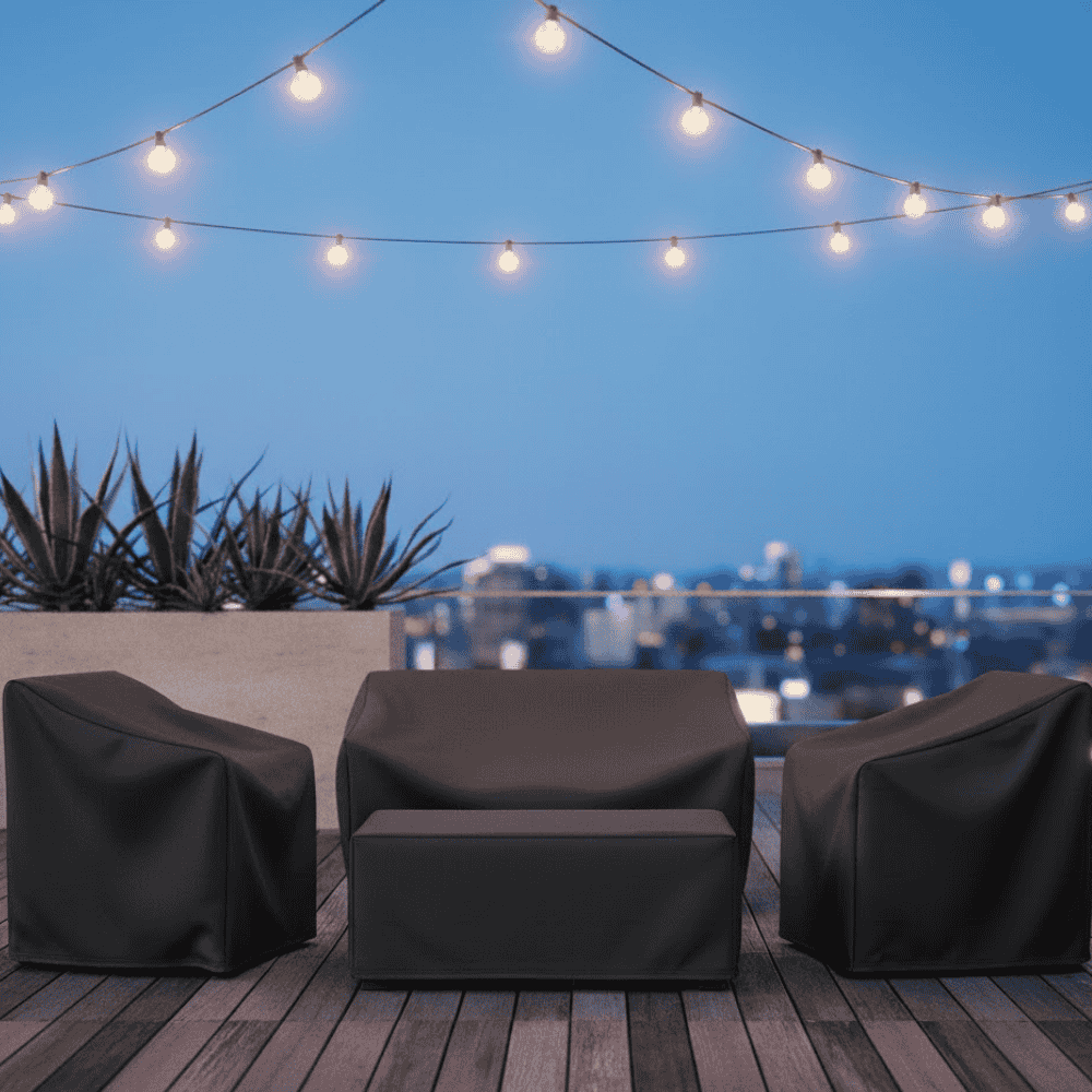 Black garden furniture covers on patio chairs and table at dusk