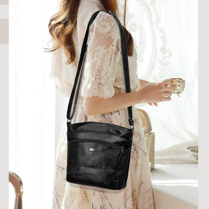 Black crossbody shoulder bag for women viewed from the side, showing slim profile