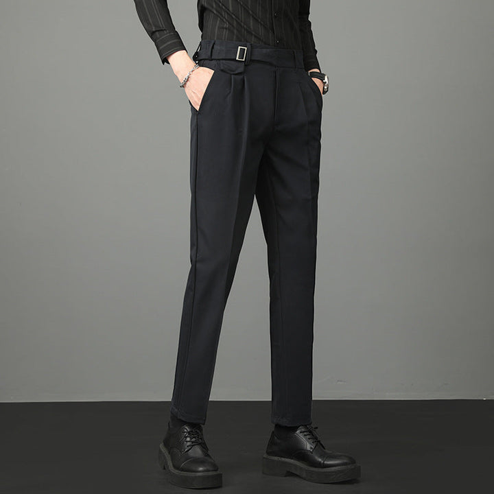 Side view of man modeling black tailored trousers with belt loops and side pockets.