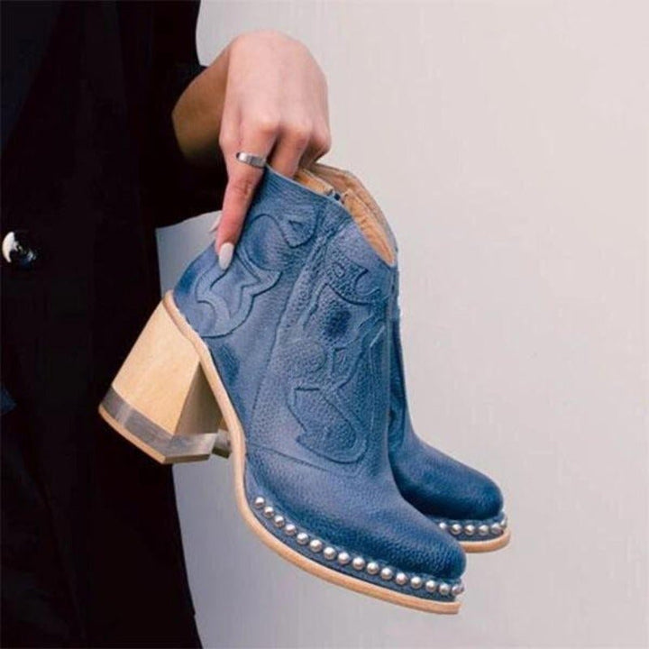 Pair of chic western cowboy ankle boots with cut-out sides displayed on clean background