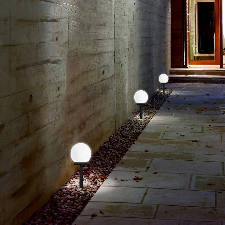 Garden decor featuring spherical solar lights highlighting bushes and patio borders.