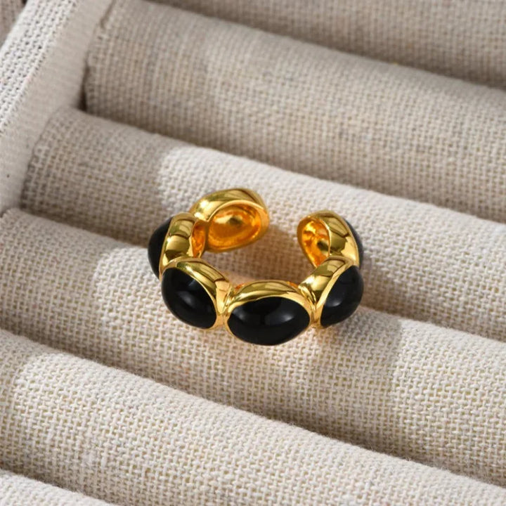 Product studio shot of the gold-plated black stone ring and ear cuff in a jewelry box