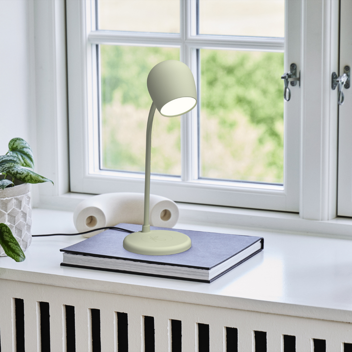SmartGlow LED Lamp in Dusty Olive placed on a book near a window
