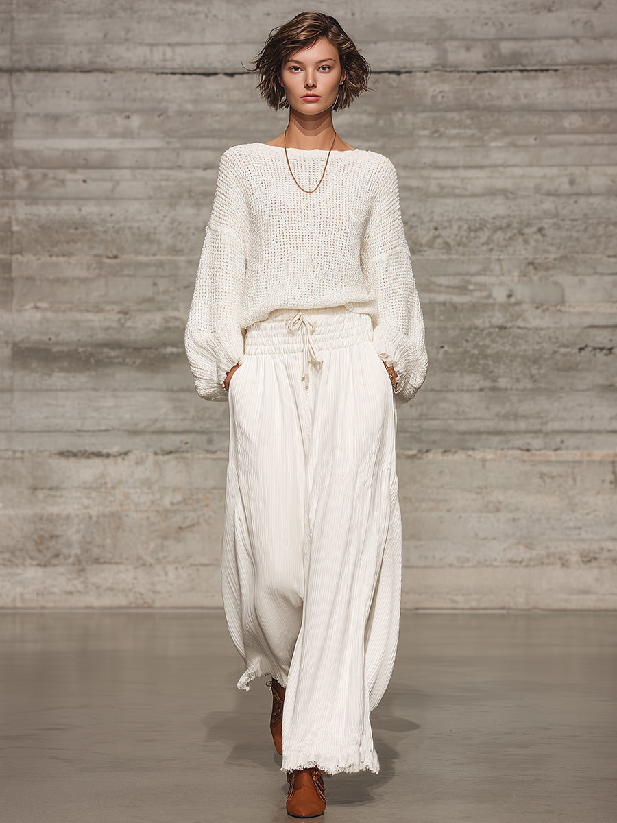 Full-length front view of a model wearing white wide-leg trousers and a knitted sweater.