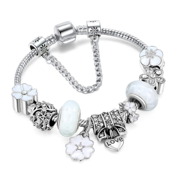 Close-up of women's silver charm bracelet featuring delicate flower design