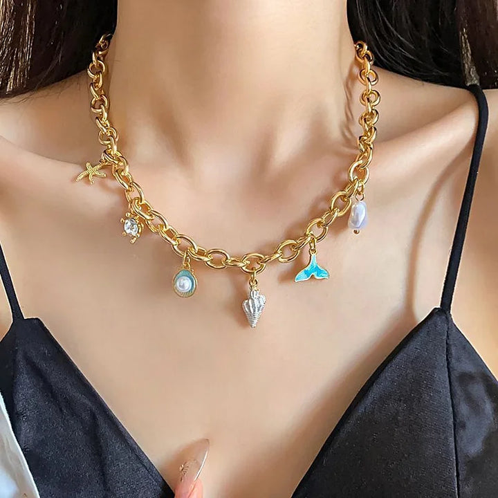 Gold shell necklace with marine charms worn on a person