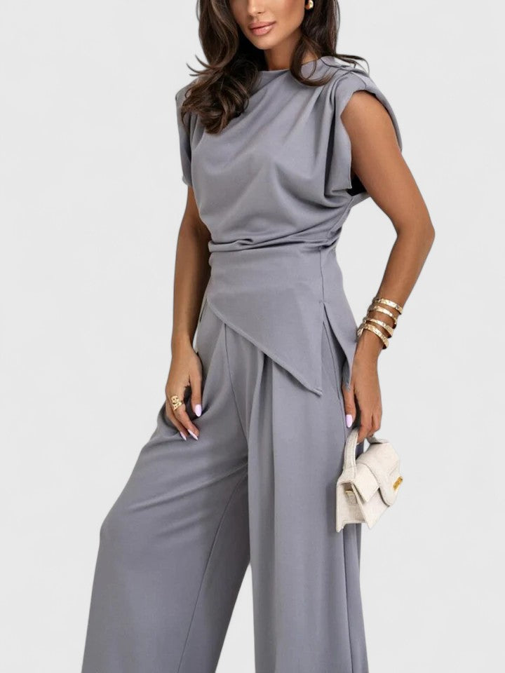 Modern smart casual wear featuring a draped sleeveless blouse and pants