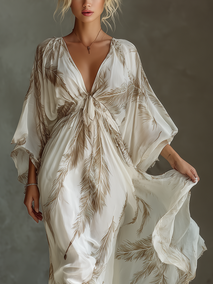 Close-up of the deep V-neckline and front tie detail on the cream feather print maxi dress.