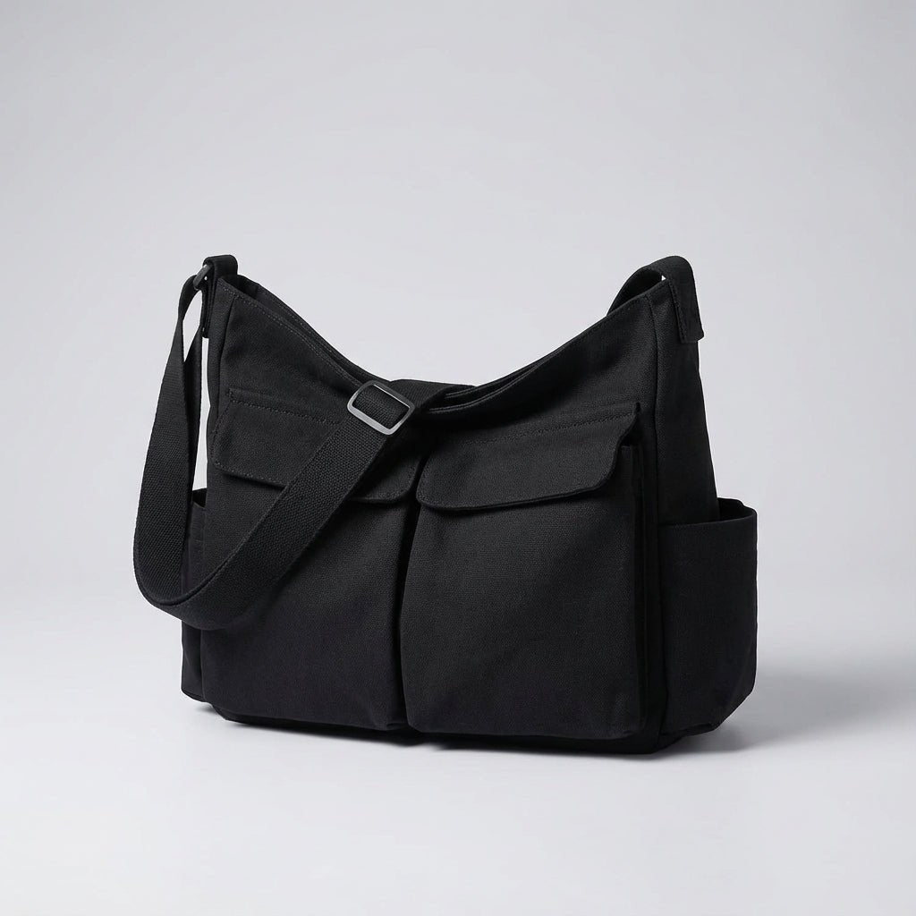 Black canvas messenger bag with adjustable strap and multiple exterior pockets displayed on neutral background