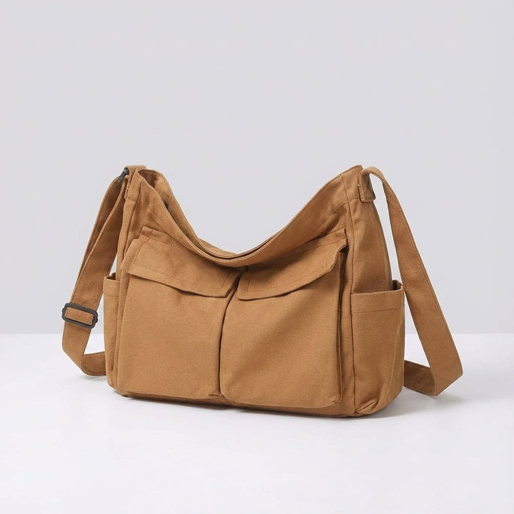 Brown canvas messenger bag showing front flap pockets and sturdy construction