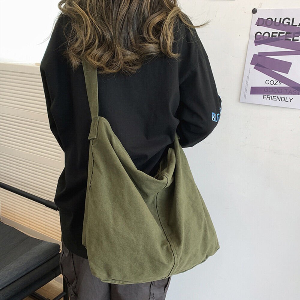 Person wearing a green canvas tote bag over the shoulder