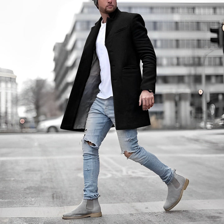 Man wearing a black slim-fit topcoat in an urban setting