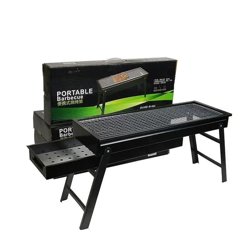 Portable folding charcoal grill set up with storage box behind it