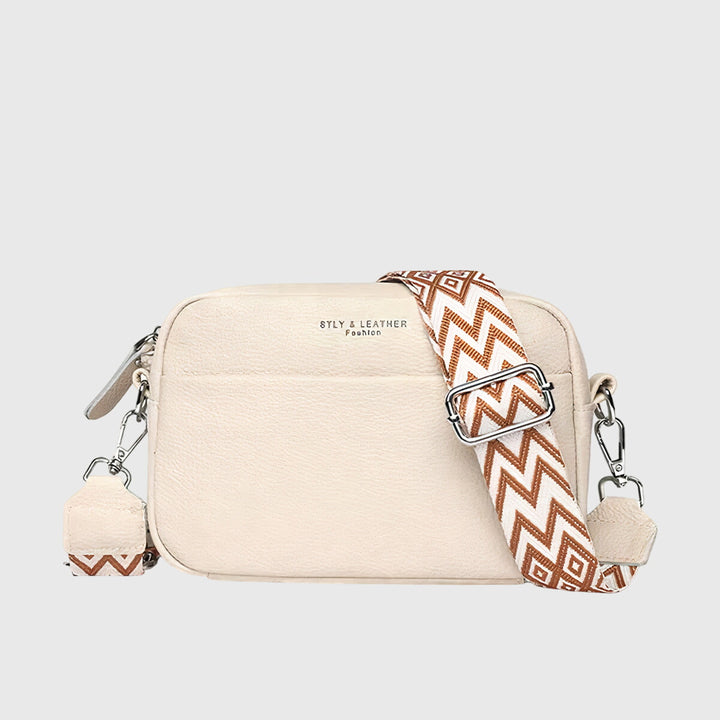Women's beige crossbody handbag with a brown geometric patterned strap
