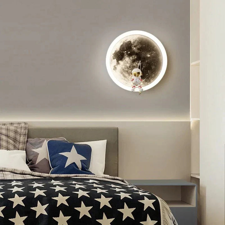 White body moon wall lamp glowing softly above a modern child's bedroom bed