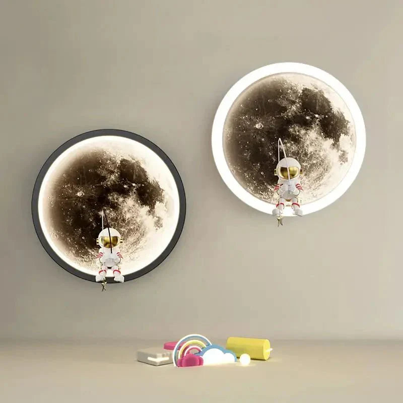 Black and white 3D moon LED wall lamps mounted on a neutral wall with astronaut figures