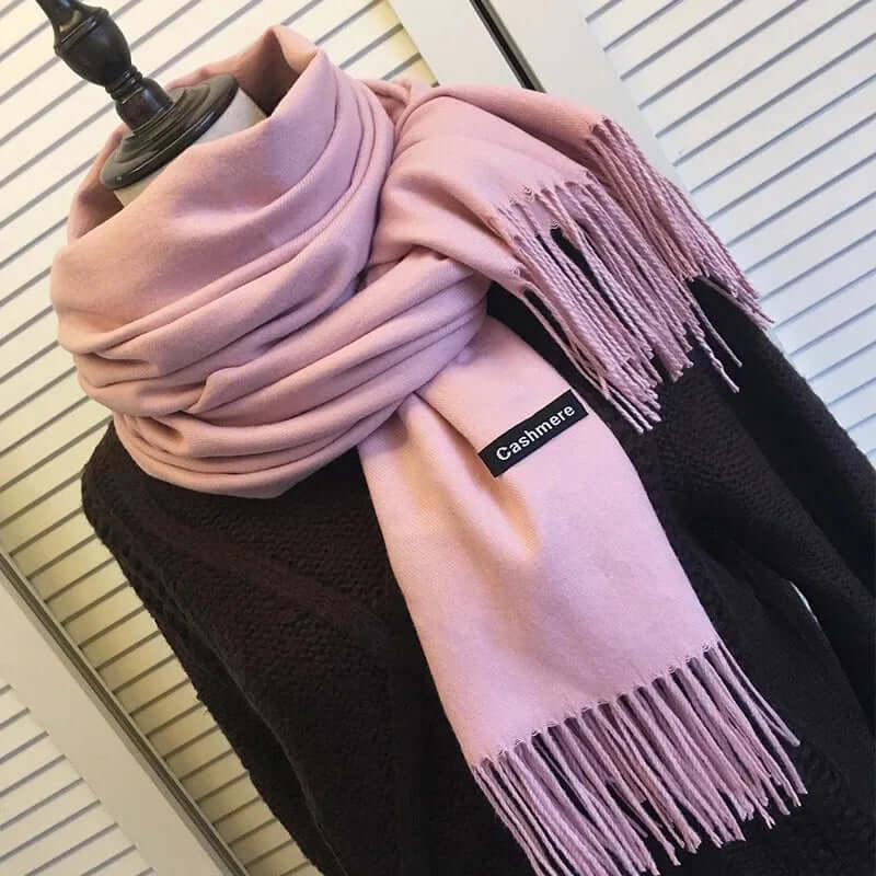 A soft pink women's winter scarf neatly draped around a mannequin torso.