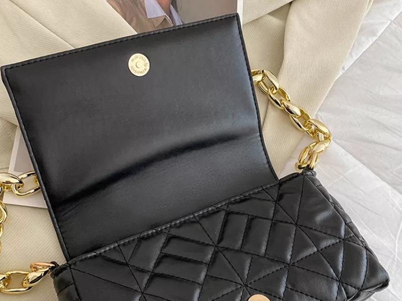 Side profile of green jacquard flap bag showing slim design
