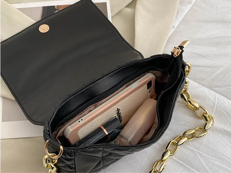 Green and black designer handbag with metallic shoulder chain
