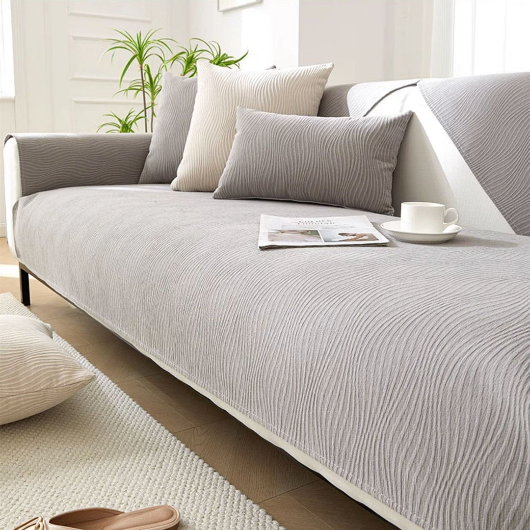 Modern light gray textured sofa cover draped over a stylish couch