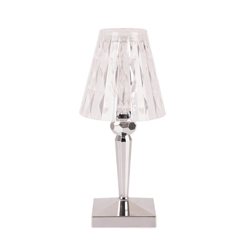 Clear crystal table lamp with silver base against a plain white background