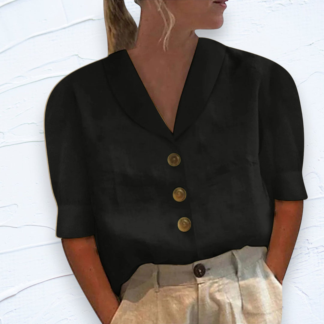 Woman wearing a black collared button blouse with short sleeves