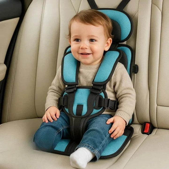 Toddler sitting comfortably in a blue portable child car seat with a five-point harness.