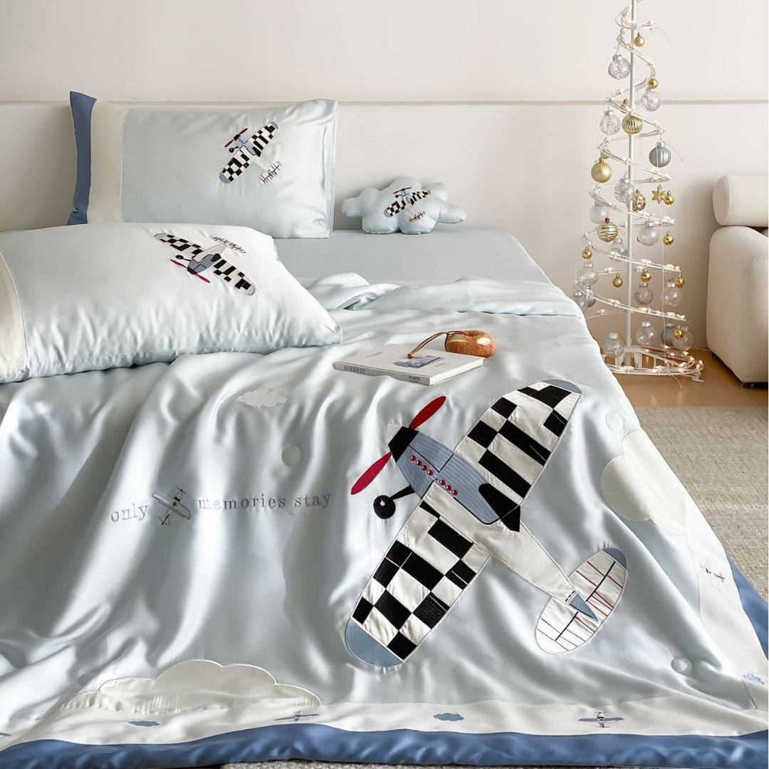 Children's bedding set with retro airplane appliqué and matching pillowcase on a made bed