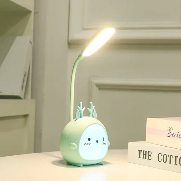 Blue deer USB rechargeable reading lamp sitting on a white desk surface