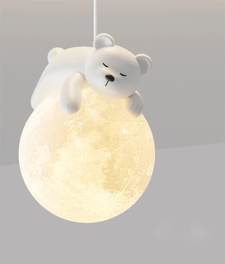 Close-up view of the white sleepy bear pendant light illuminating a moon-shaped shade