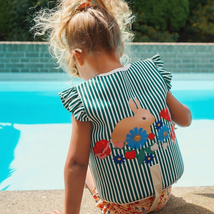 Child wearing bright swimming aid and adjustable swim vest for water safety