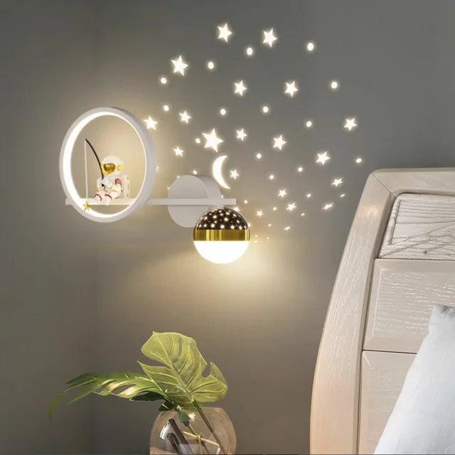 White right astronaut children's wall lamp mounted on gray bedroom wall with star projection