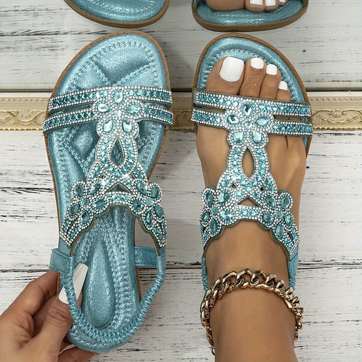 Top-down view of blue rhinestone jeweled flat sandals with open toe