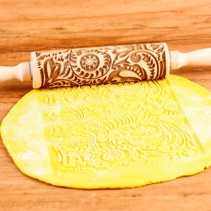 Detail shot of carved patterns on a wooden Christmas cookie stamp rolling pin