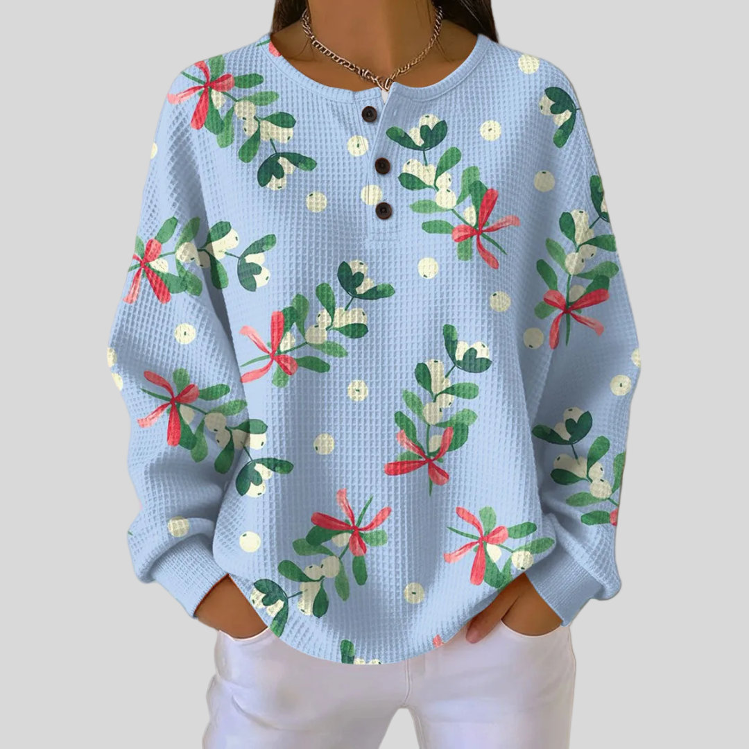 Woman wearing light blue holiday mistletoe print sweatshirt with button placket