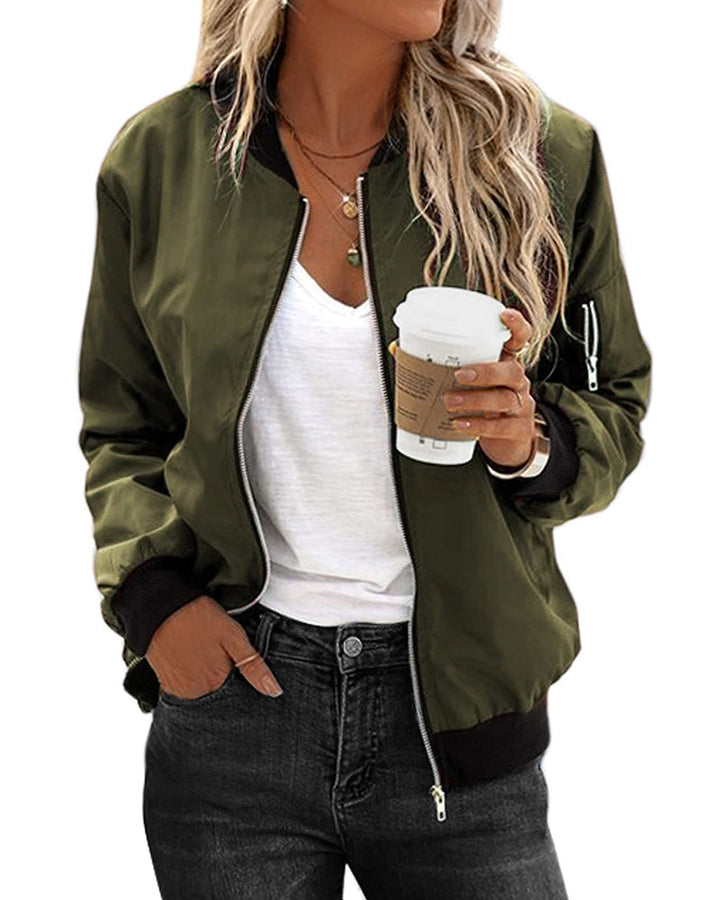 Woman wearing an army green bomber jacket with a white top and dark jeans