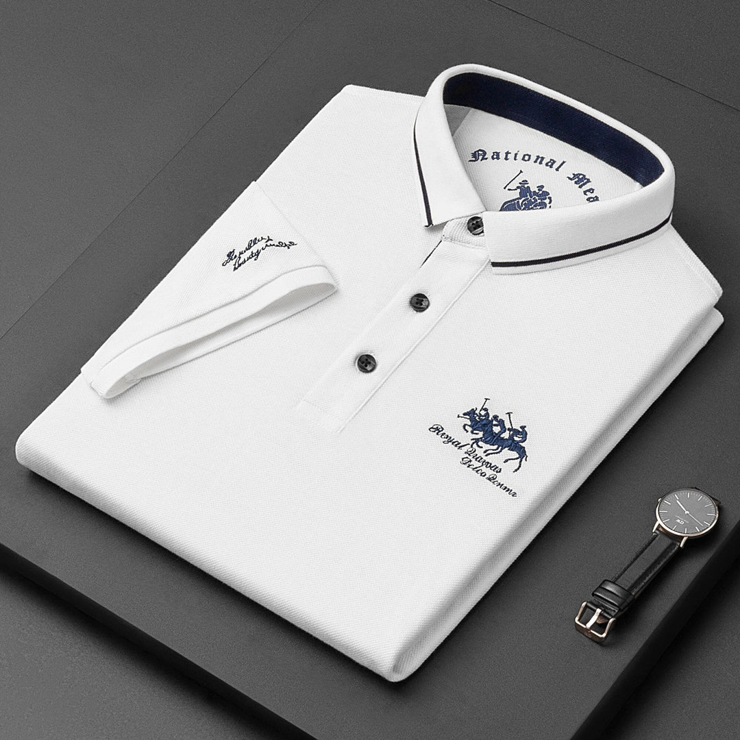 White men's classic polo shirt folded neatly on dark surface