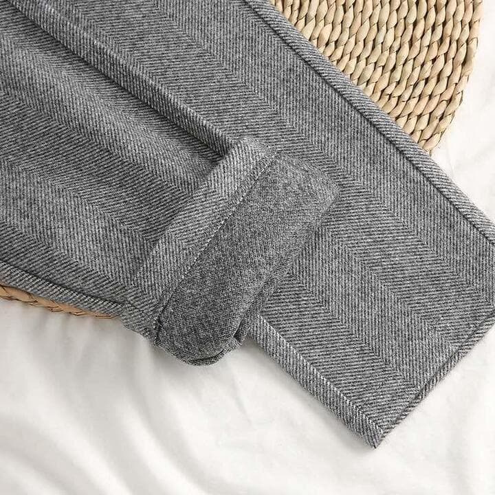 Detailed view of gray herringbone textured fabric folded on a surface