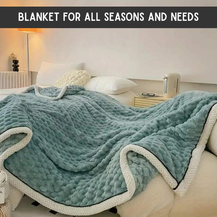Green CloudTouch weighted blanket draped elegantly over a bed in a modern bedroom