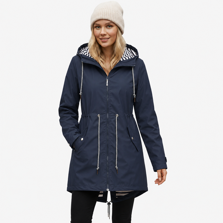Model wearing a navy blue waterproof rain jacket with striped hood lining