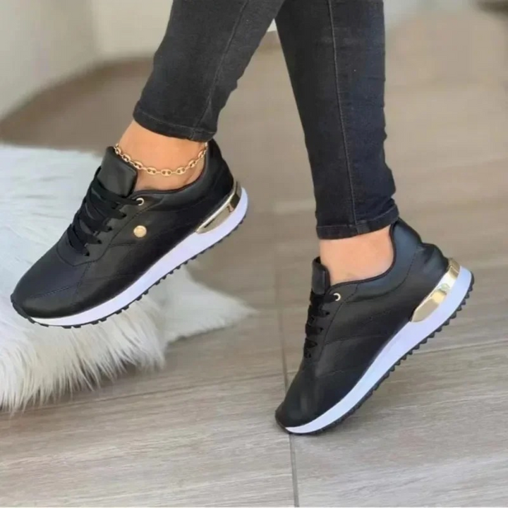 Woman wearing black fashion sneakers with black jeans