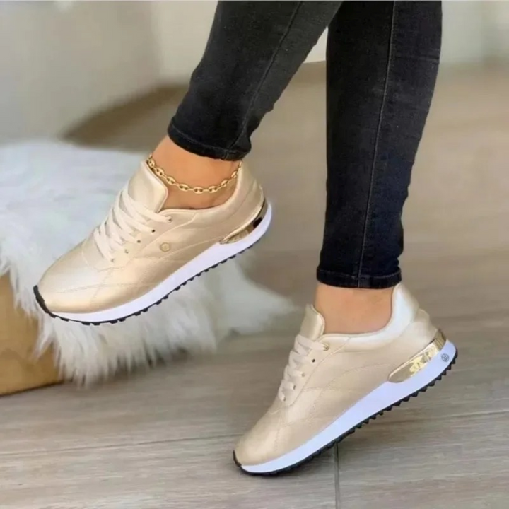 Woman wearing rose gold fashion sneakers with black jeans