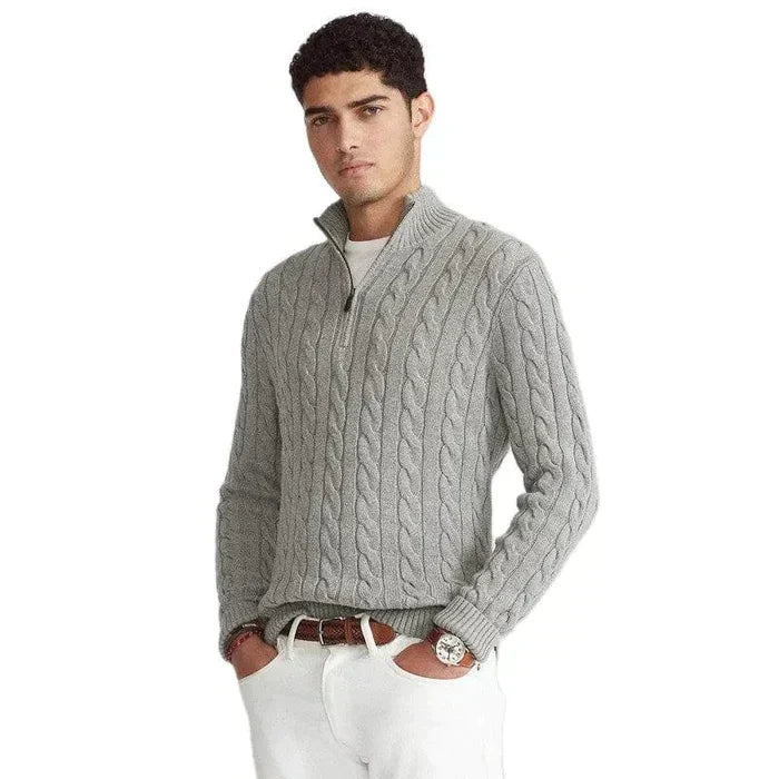 Man wearing grey half-zip cable knit sweater outdoors with white trousers and brown belt