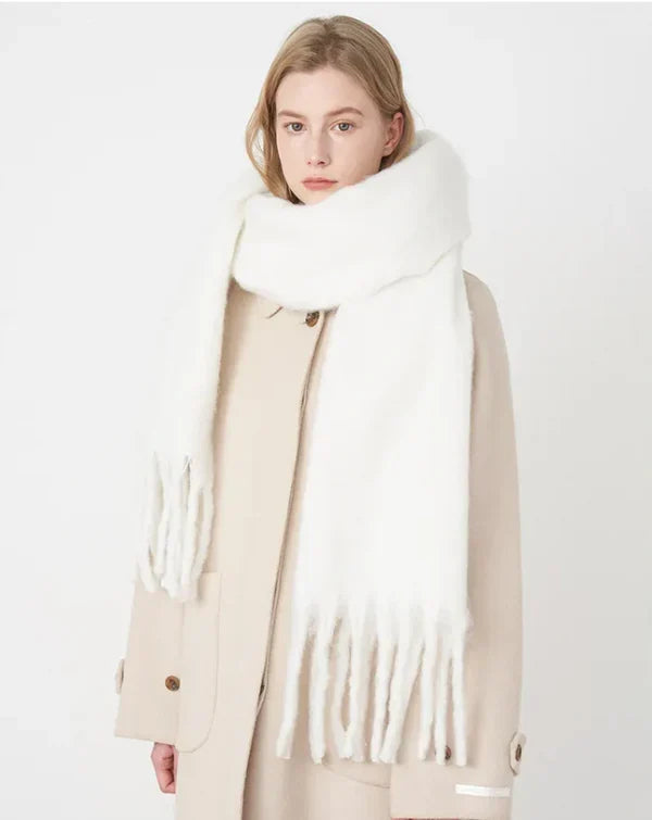 Woman wearing a soft white winter scarf with fringe details