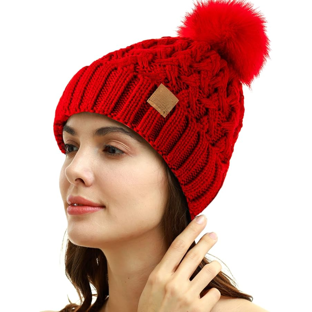 Woman wearing a vibrant red winter pom beanie with classic ribbed design